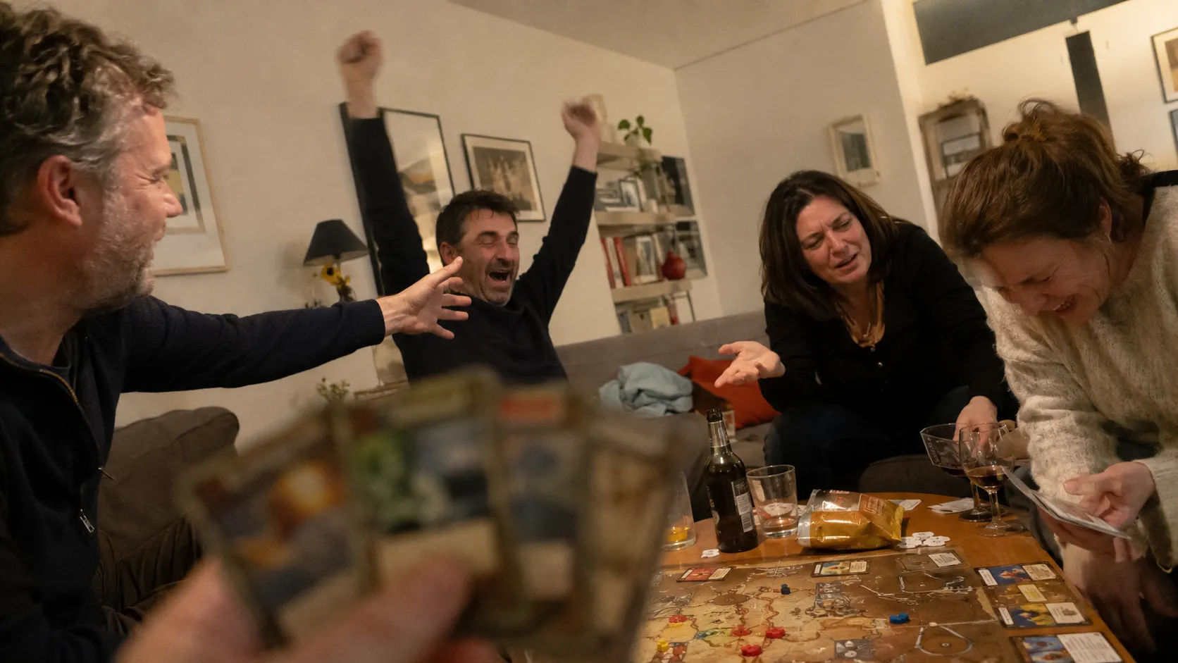 Deux parents assis face à leur enfant dans un salon lumineux, à hauteur de regard, dans un moment de conversation apaisée